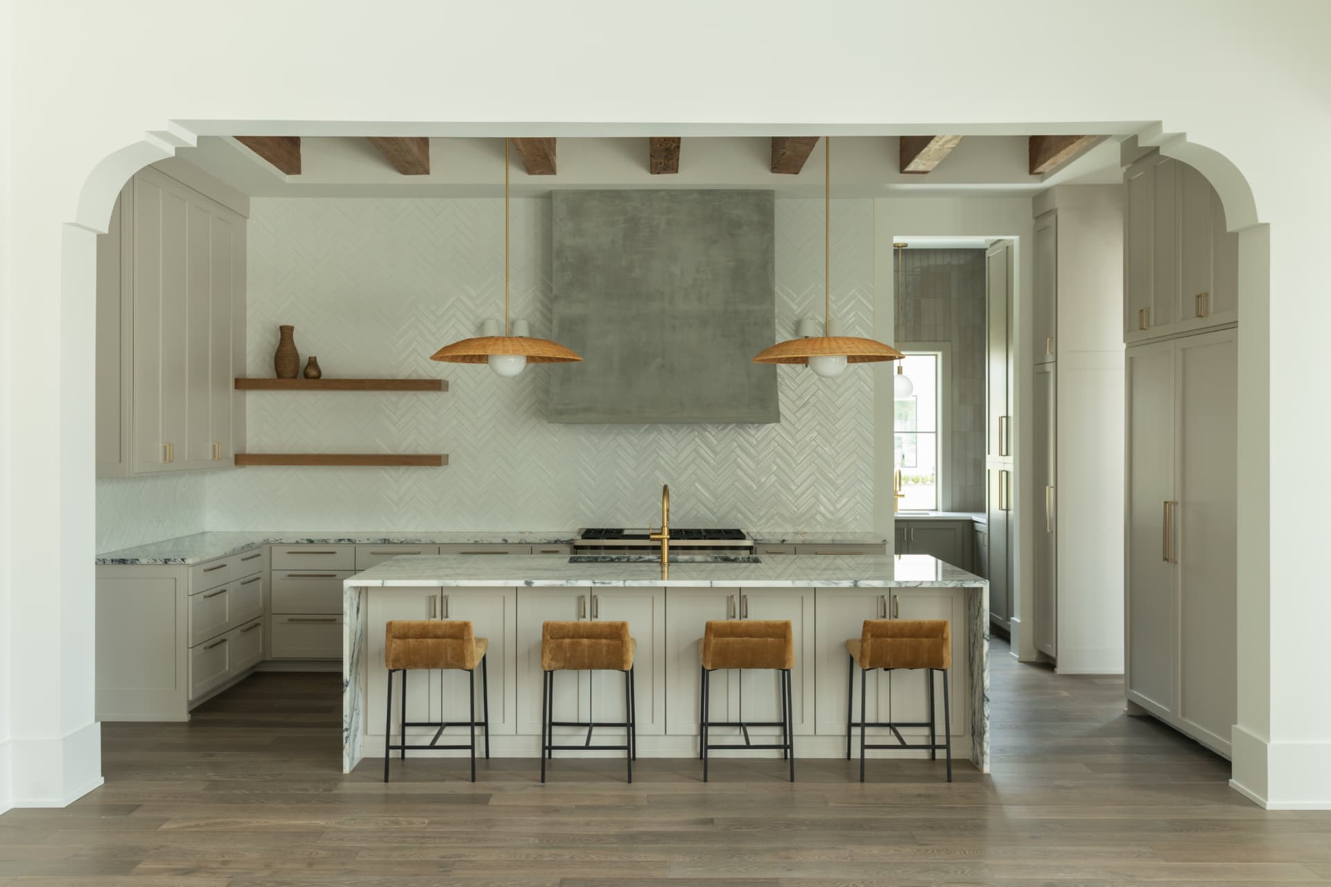 Kitchen with a marble island, plaster hood, and reclaimed timber beams in a Burns Construction Group custom home